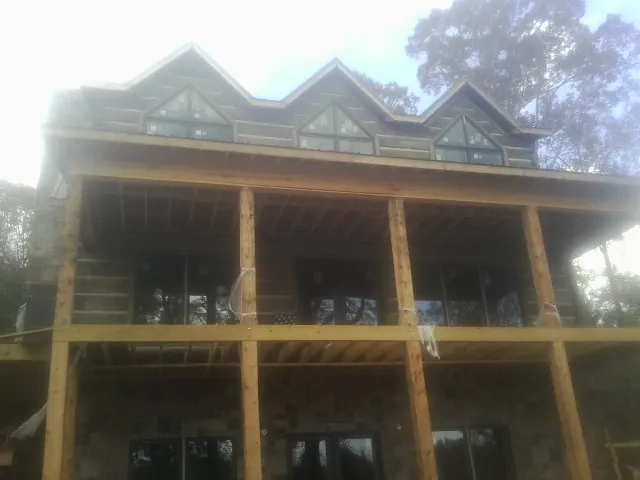 Dormers and porch framing on a large log home under construction — Roof Coating work by our crew in Varnville