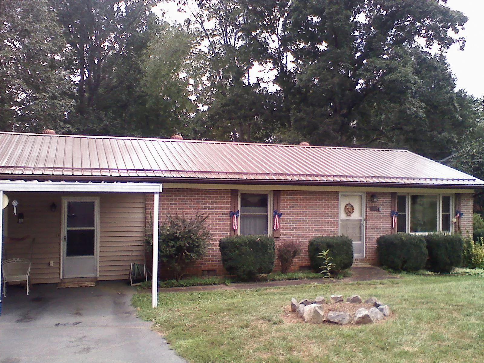 Bronze metal roof and carport on a brick ranch home — Roof Repair work by our crew in Varnville